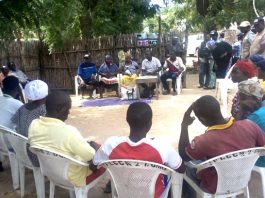 Mrs Yelwa sitting in the Middle of two men as one of the Executive of VSLA Pro-Act project in Dumne Community of Adamawa State